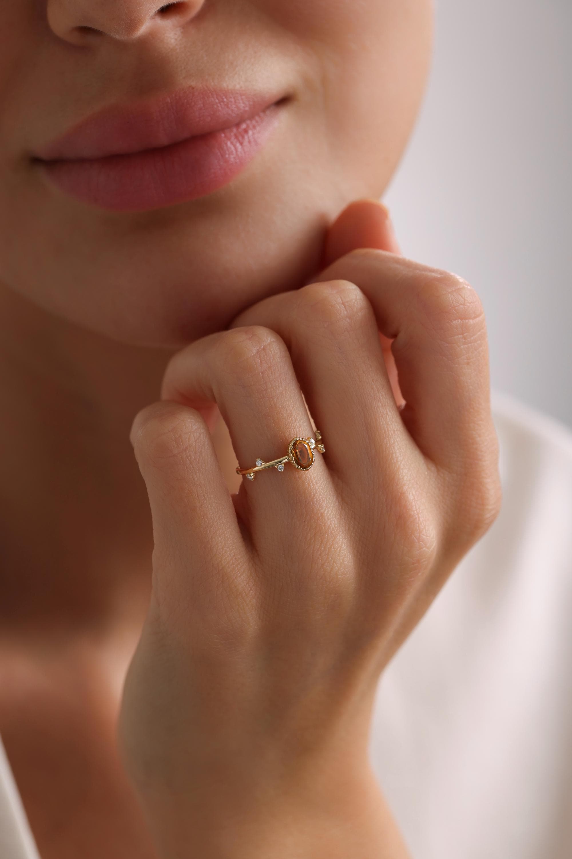 May include: A gold ring with a brown oval gemstone and small diamonds on either side.
