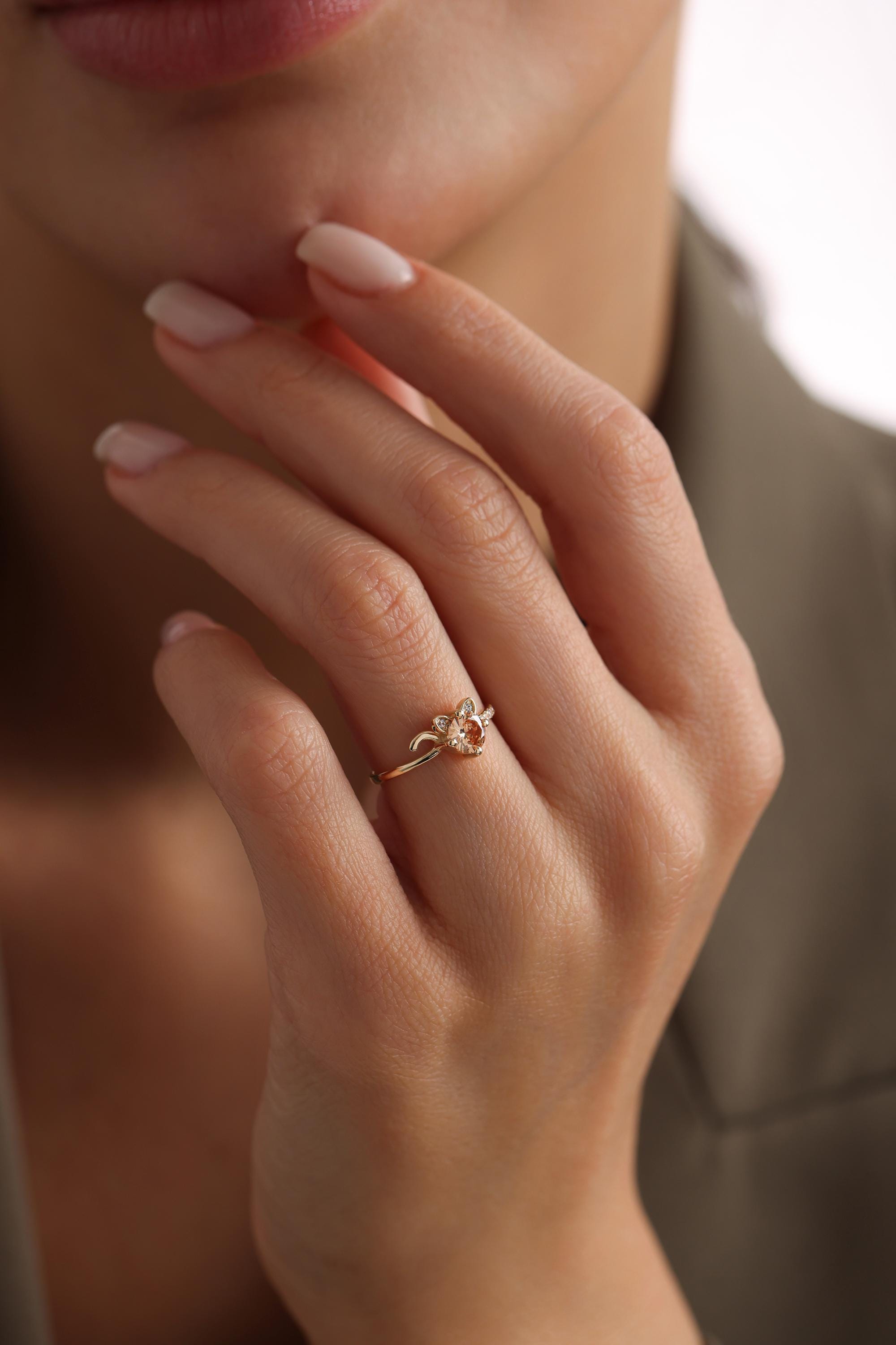 A close-up of a person's hand wearing a gold ring with a small gemstone.
