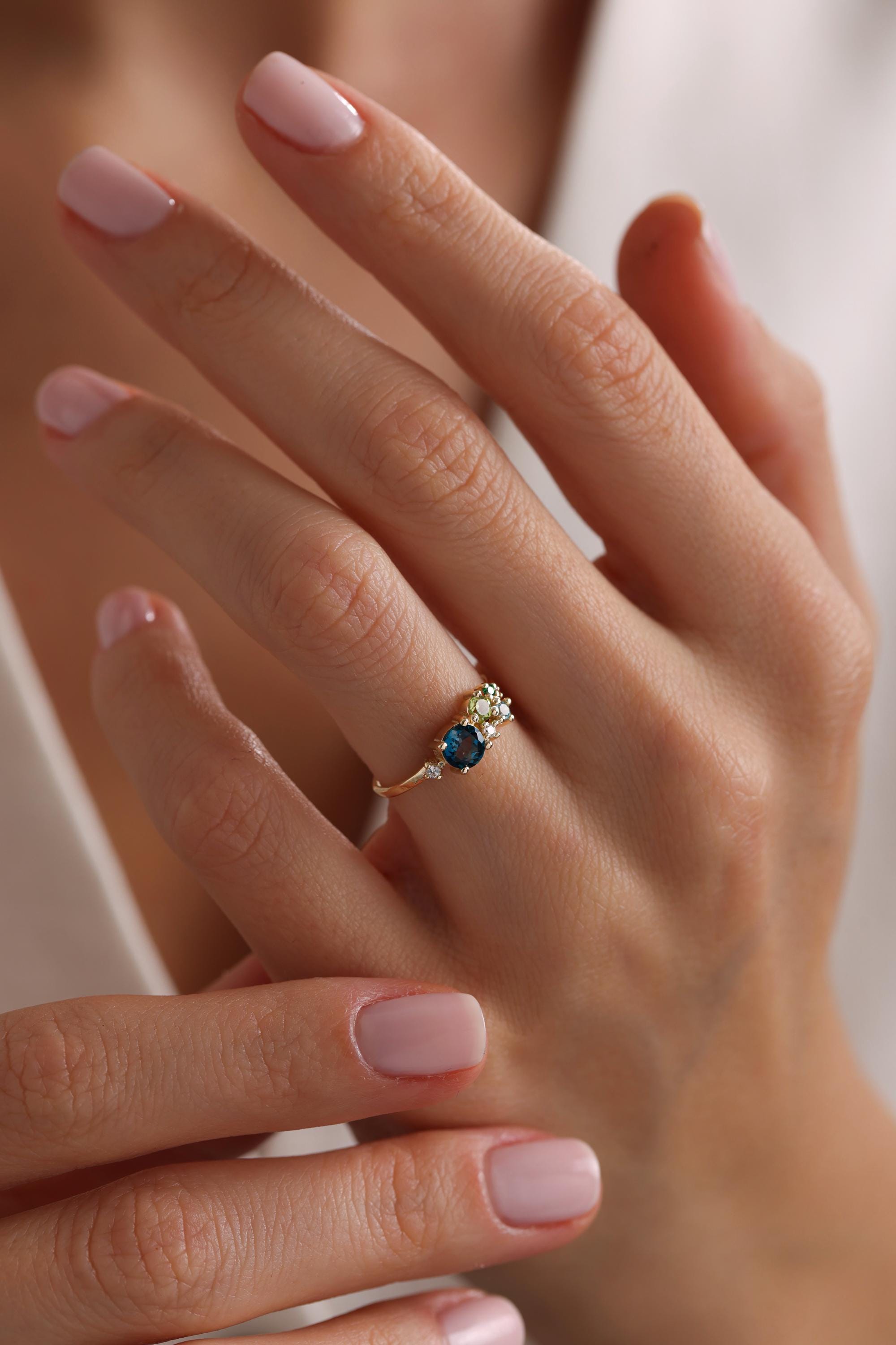 May include: A gold ring with a blue gemstone and smaller white gemstones