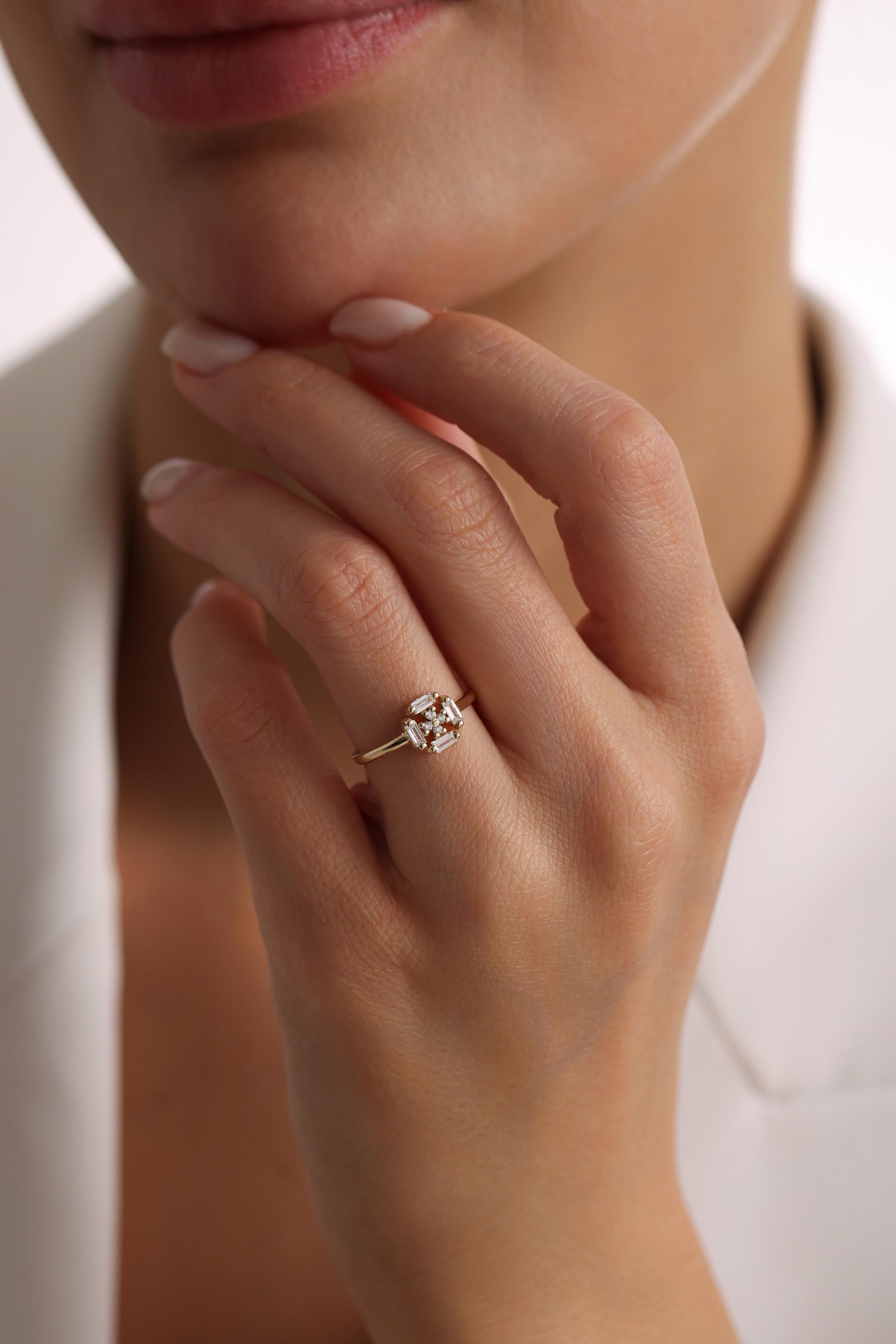 A close-up of a person's hand wearing a gold ring with a diamond.