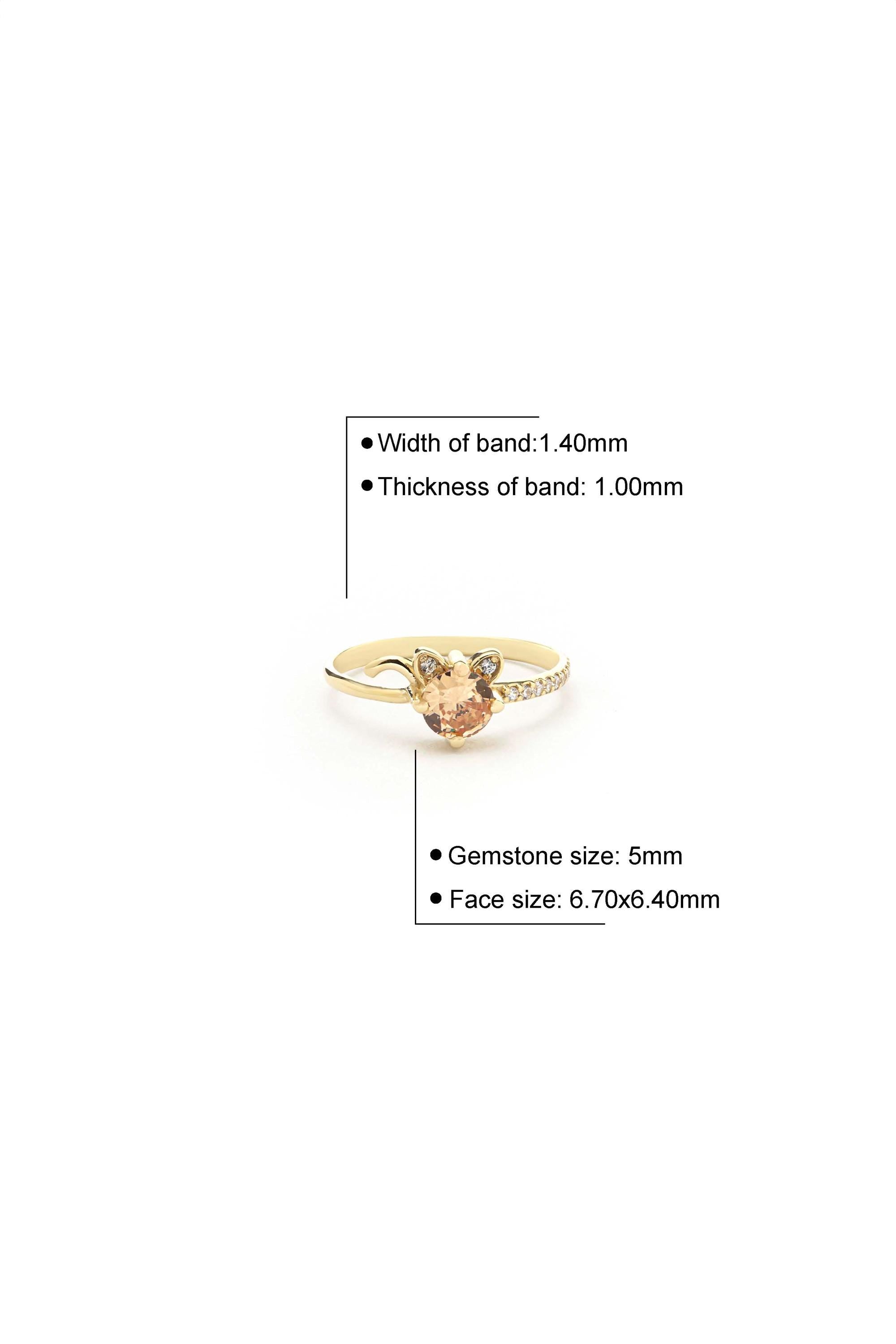 a gold ring with a gemstone set in it, along with some specifications about the ring's size and design.