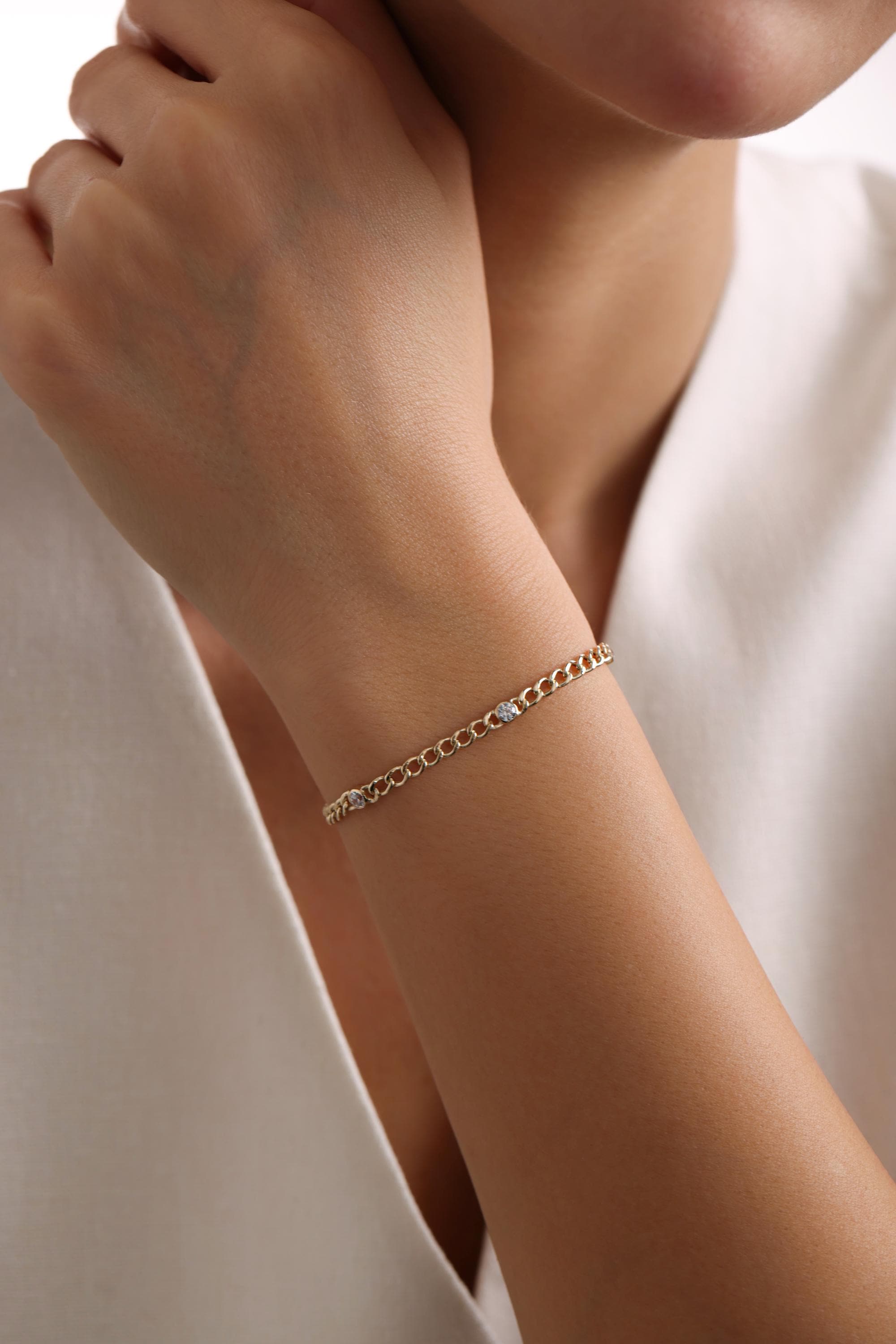 May include: A gold chain bracelet with small round diamonds